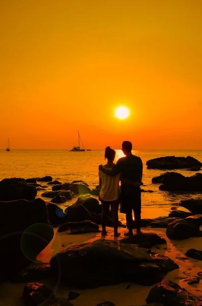 Couple sweetheart standing on a rock by the sea and watching sun — Stock Photo, Image