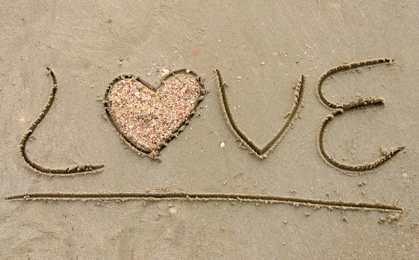 "Love "written on sandy beach — стоковое фото