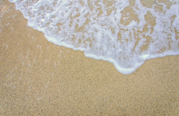 Bubbla våg av havet på sandstranden — Stockfoto