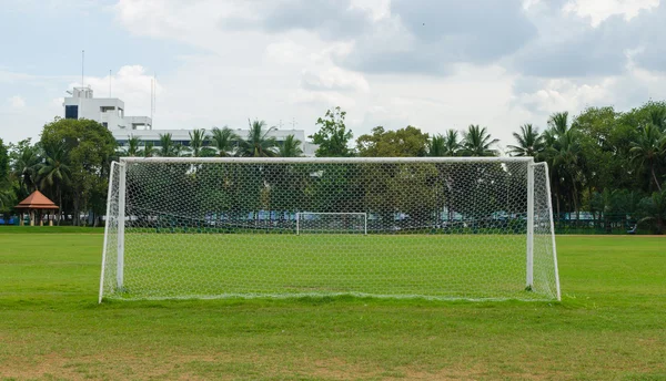 soccer goal at the end of a empty field at a park