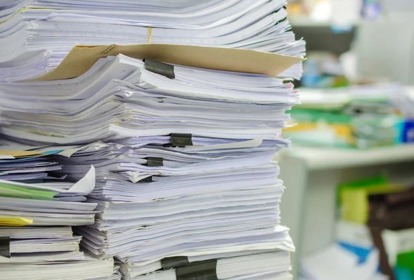 Stapel von Dokumenten auf dem Schreibtisch stapeln sich hoch und warten darauf, verwaltet zu werden. — Stockfoto