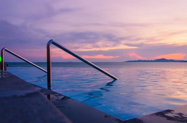 Lyxiga poolen framför havet på under solnedgången — Stockfoto