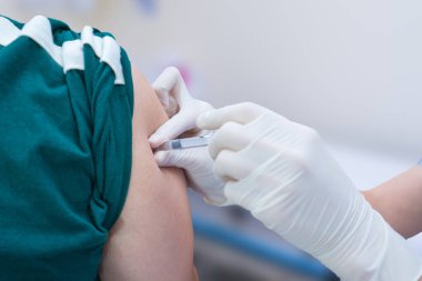 Enjeksiyon için elinde şırınga olan hemşire COVID-19 ya da grip antivirüsü aşısını hastanede yapıyor. Sağlık Hizmetleri Konsepti.