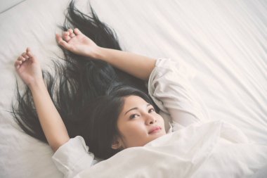 Evdeki yatak odasında uyuyan genç kadın..