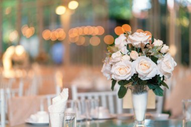 Restoranda çiçek kompozisyonu ve lüks bir akşam yemeği için masa hazır. Zarif ziyafet dekorasyonu.