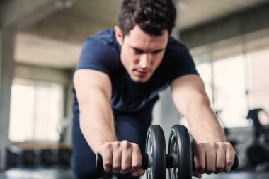 Sporcu ya da yakışıklı spor salonunda karın kaslarını güçlendirmek için karın kaslarıyla egzersiz yapıyor..