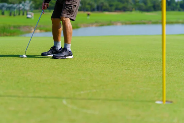 ゴルフコース中に緑の上に置かれたゴルフボールのための準備ゴルファー — ストック写真