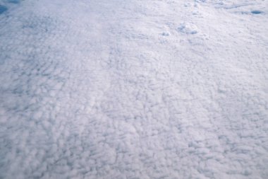 Mavi gökyüzü ve bulutlar uçağın penceresinden görüldüğü gibi.