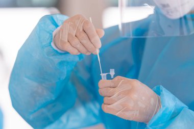 PPE giysisi test koronavirüsü (covid-19) olan doktordan genzinden antijen test kitine kadar. ATK.