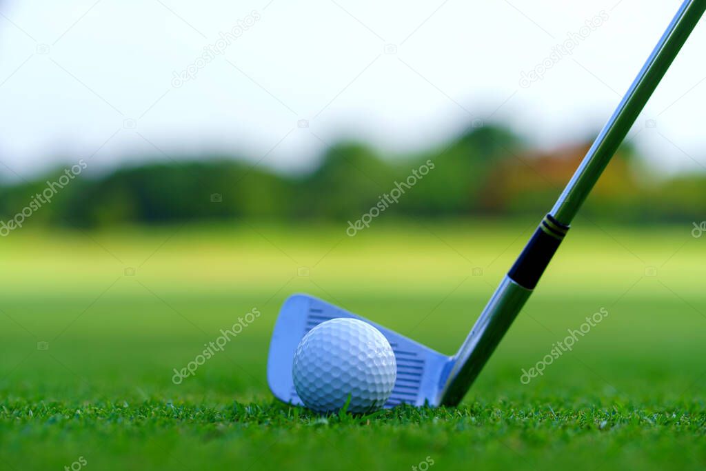 Man Golfer Hitting Ball with Club on Beatuiful Golf Course.