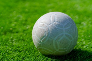 Yapay arka planda yeşil çimlerde plastik futbol topu.
