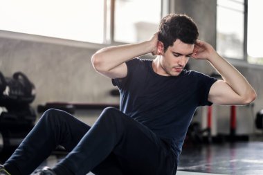 Sporcu ya da yakışıklı spor yapan adam spor salonunda karın egzersizi yapar..