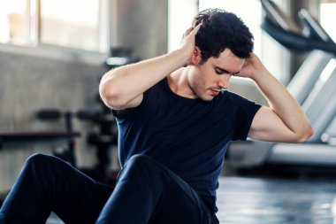 Sporcu ya da yakışıklı spor yapan adam spor salonunda karın egzersizi yapar..