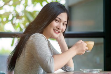 woman drinking cappuccino coffee at vintage coffee cafe.