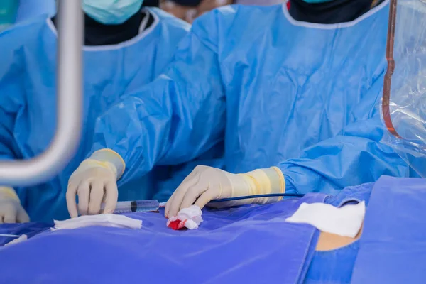 surgeon team working in operating room, Stem cells operation, Plasma in syringe, Health care concept