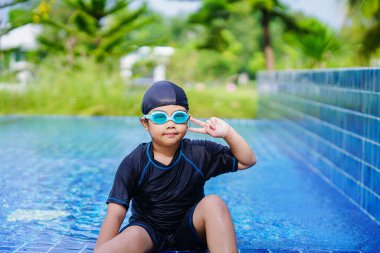 happy children Smiling cute little girl in sunglasses in swimming pool.