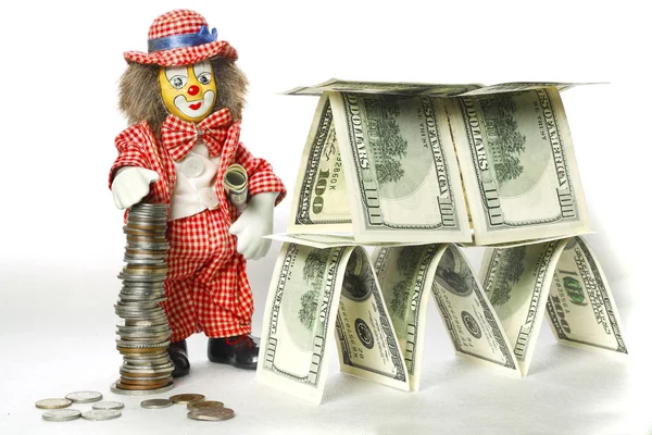 Clown in der Nähe eines Dollar-Hauses Stockbild