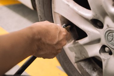 Adam eli, araba lastiğinde nitrojen lastik dolum makinesiyle çalışıyor.