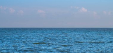Mavi Deniz Okyanusu mavi gökyüzünün altında kabarık beyaz bulut deniz manzarası arka planda yaz tatili
