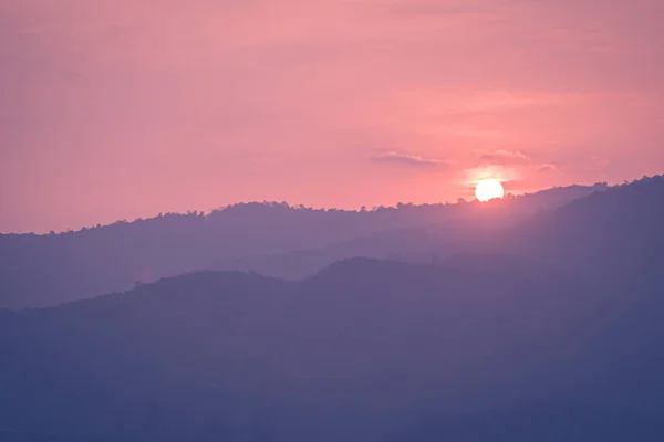 beautiful mountain range landscape with pink pastel sunset sky with hills on background.
