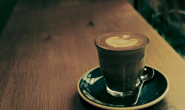 Yaprak şeklinde köpüklü bir fincan kahve.