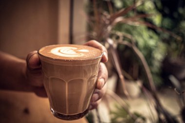 Yaprak şeklinde köpüklü bir fincan kahve.