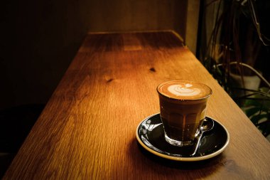 Yaprak şeklinde köpüklü bir fincan kahve.