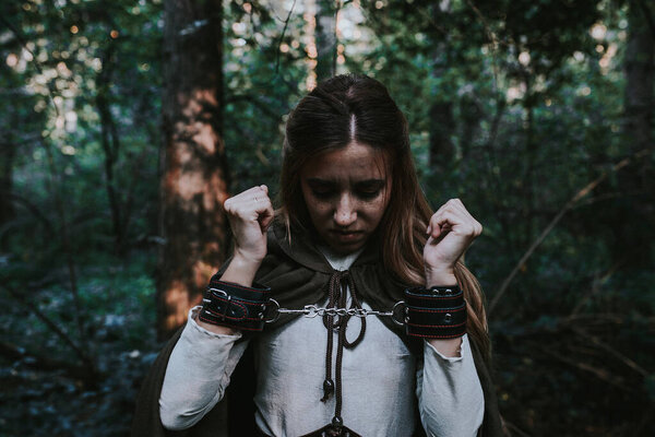 girl in a historical dress in a coniferous forest