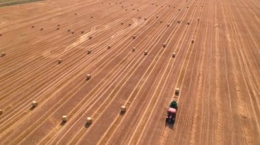 Balya makinesi tarlada saman toplayıp büyük balyalar yapıyor. Tarım kalitesi 