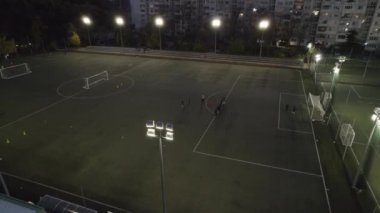 Futbol ya da futbol sahası, gece yarısı ışıklarla dolu bir parkta.