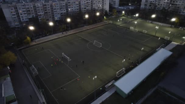 Přátelé hrají fotbal v noci s výhledem na město v pozadí — Stock video