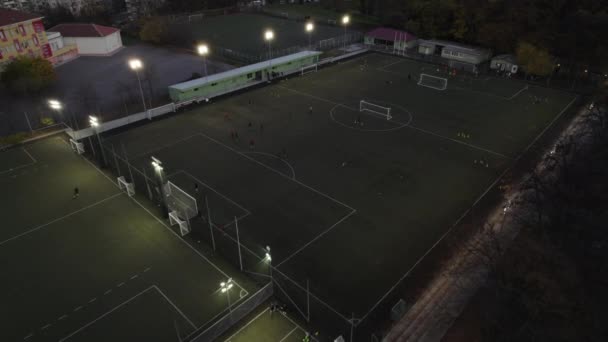 Футбольные тренировки на игровом поле ночью, вид с воздуха — стоковое видео