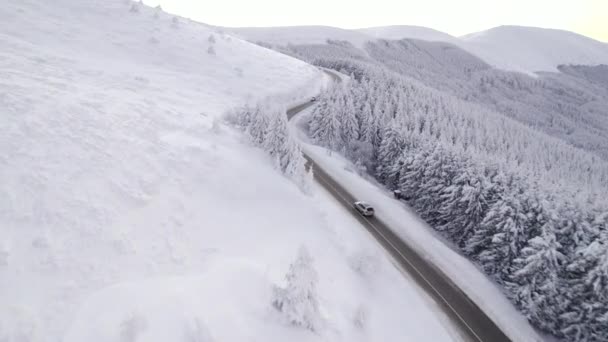 Drone κυνηγούν ασημί SUV επιτάχυνση ανηφόρα στο δρόμο το χειμώνα, εναέρια άποψη — Αρχείο Βίντεο