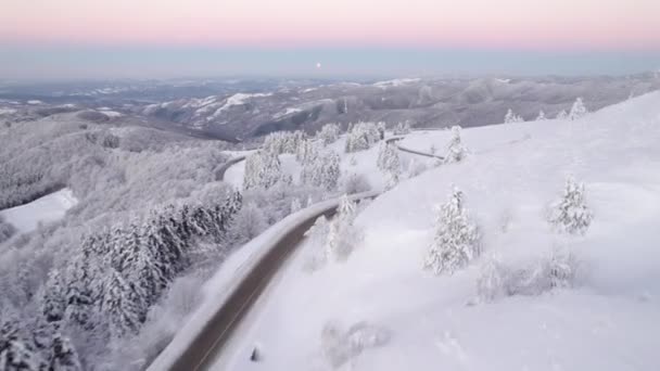 Vista aérea del camino de montaña de invierno con hermoso valle nevado debajo — Vídeos de Stock