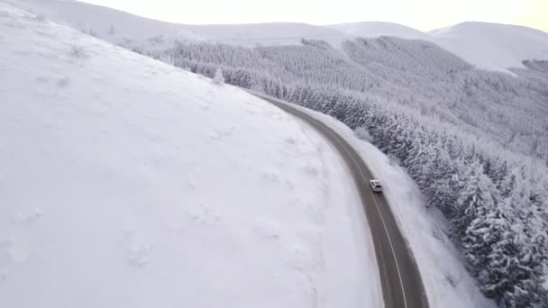 Drone perseguindo SUV excesso de velocidade na estrada de montanha de inverno curvilínea. Férias viajando, feriados — Vídeo de Stock