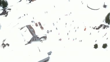 Bulgaristan 'ın Pamporovo kentindeki kayak merkezinde çok sayıda kayakçı ve snowboardcu dağın yamacında