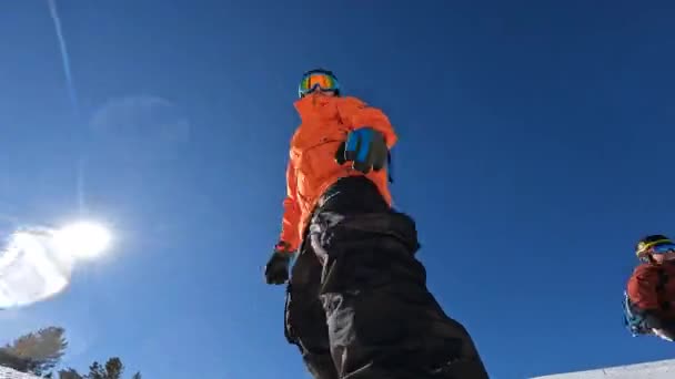 Laag uitzicht op Friends snowboarden in zonnige dag — Stockvideo
