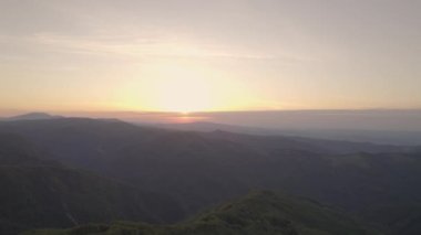 Bulgaristan 'daki dağların tepelerinde günbatımı yükseliyor. 