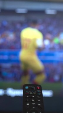 vertical video remote control changing different football matches channels . High quality 4k footage