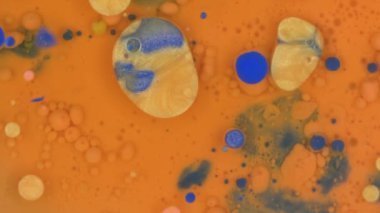 orange blue and golden ink bubbles background macro texture rotating . High quality 4k footage