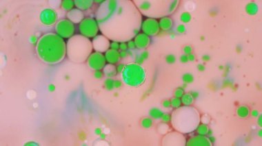 pink and green ink bubbles background texture rotating . High quality 4k footage