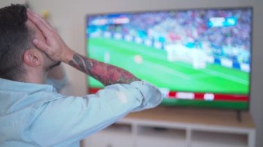 Hüsrana uğramış bir adam futbol maçı izliyor. Yüksek kaliteli FullHD görüntüler