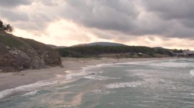 Dalgaların çarptığı ve doğanın yavaşladığı altın deniz kenarı günbatımı. Yüksek kalite 4k görüntü