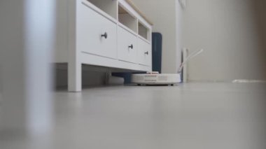 Robot elektrikli süpürge masanın etrafını temizler, akıllı sensörler. Yüksek kalite 4k görüntü