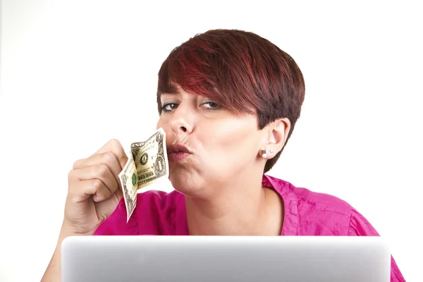 Mujer usando laptop y besando un dinero —  Fotos de Stock