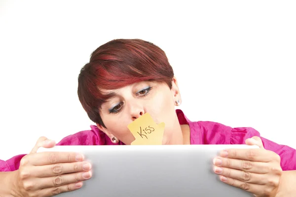 Woman using laptop and kissing the screen — Stock Photo, Image
