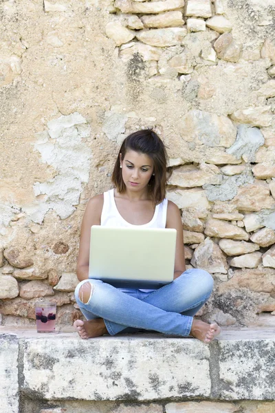 Vrouw zitten op een muur — Stockfoto