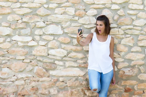 Mulher surpreendida com o celular — Fotografia de Stock