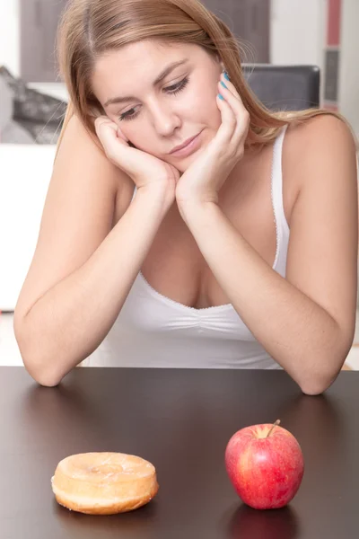 Woman choosing between Fruits and Sweets — Stock Photo, Image