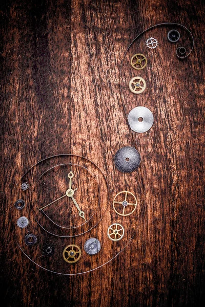 Various clock parts on a rustic wood